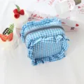 Primo piano della trousse trucco a quadretti blu e bianchi con volant e dettagli graziosi. - Quadri Blu Lago