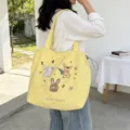 Vista dettagliata della borsa tote gialla in tela con simpatico ricamo di coniglio e spazio. - Trio Coniglio Doppio Strato Spalla / Giallo
