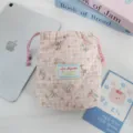 Detalle de la bolsa de almacenamiento acolchada a cuadros rosas, bolsa con cordón y tierno perrito. - Cachorro de cuadros rosas