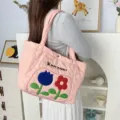 Detail view of the cute pink quilted tote bag with floral embroidery and shoulder strap. - Dual Color Floral Quilted / Pink