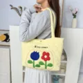 Detailed view of the yellow quilted shoulder bag with embroidered flower and cute rabbit logo. - Tulip Floral Style (Calabash Quilt) / Yellow