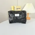 Detailed view of black quilted cosmetic bag with soft PU material and neat zipper closure. - Small Bowknot Black