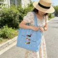 Primo piano esterno che mostra il ricamo del bassotto e il design con coulisse della borsa. - Cane con Cappello Spalla Doppio Strato: Blu