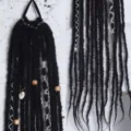 Vue détaillée de la queue de cheval en dreadlocks synthétiques de 60cm avec perles et coquillages. - Noir