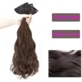 Clip-in curly hair extension detail showing rich texture and natural wavy brown strands. - Tan