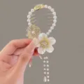 Primer plano de un elegante pasador de pelo con perlas blancas y borla de flor. - Bead flower tassel hairpin
