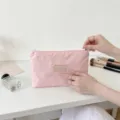 Primo piano della borsa cosmetica rosa con zip, organizer da viaggio portatile e leggero. - Taglia S / Rosa