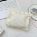 Detailansicht der zarten Spitzen-Kulturtasche, zeigt weiches und elegantes Aufbewahrungsdesign. - Beige