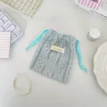Gros plan détaillé de la pochette cordon en dentelle bleue avec texture de motif. - Bleu