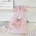 Pink gingham shoulder bag detail featuring large bow strap and cute red cherry print design. - Pink