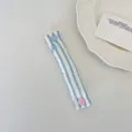 Blue and white striped fabric cable organizer detail view with cute heart button closure. - Sea Salt Blue Heart Stripe