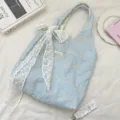 Detail view of light blue quilted canvas tote bag featuring white floral embroidery and lace bow. - Lace Bow and Small Flower Style / Light Blue