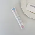 Detail view of the pastel plaid cable organizer strap with cute heart and round snap buttons. - Dopamine Color Plaid