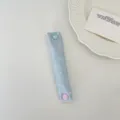 Close-up detail of a cute light blue polka dot cable organizer strap with sweet heart button. - Light Blue Satin Polka Dot