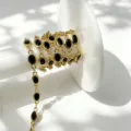 Nahaufnahme einer vergoldeten Kette mit schwarzen ovalen Zirkoniasteinen für Basteln. - Oval Einzelstein Kette / Gold Schwarzer Zirkonia