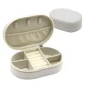 Oval PU leather jewelry box with ring rolls, necklace hooks, and compartments for safe storage. - 14.5x9.5x4.5cm / White