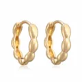 Gros plan détaillé de boucles d'oreilles créoles géométriques ondulées plaquées or 18k - Or