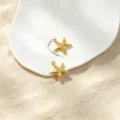 Detailed view of two gold starfish charms with size measurements on white sand - No.1 Double-Sided Starfish