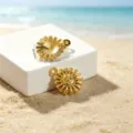 Detailed view of gold sun pendants on beach sand with dimensions 1.4cm and 1.7cm - Sun Face