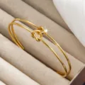 Goldener doppelter Draht Knoten offener Armreif, minimalistischer Titansstahl Schmuck. - Doppellinien-Knoten-Stil (szkk086) / Gold