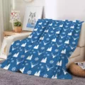Detailed view of cozy blue Christmas flannel blanket with white deer and snowflake patterns. - ZM20250827-6