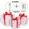 Detailansicht von 3 leuchtenden Geschenkschachteln mit roten Schleifen und USB Batteriebox. - Dreiteiliges Set / Warmweiß