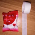 Balloon glue dots roll with red packaging on wooden background - Chinese Packaging / 100 Pieces