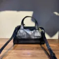 Détail sac Boston en cuir, texture noire vintage, fermeture éclair et bandoulière. - 22x11x11 cm / Noir