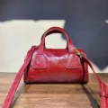 Detailed view of the retro genuine cowhide Boston handbag in dark red, featuring dual top handles - 22x11x11 cm / Red