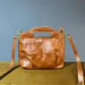Detail view of vintage genuine leather women handbag, retro brown shoulder bag with handle. - Brown