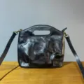 Vintage genuine leather crossbody handbag detail showcasing textured black surface and hardware. - Black