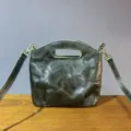 Vintage genuine leather handbag detail, dark green crossbody tote with metal hardware. - Green