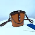 Bolso cubo de cuero genuino con colores contrastantes, correa de cadena y diseno elegante. - Caramelo