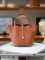 Orange leather bucket bag with top handles and lock closure, elegant daily handbag design. - L22 H21 W18cm, Silver Buckle / Gold Brown