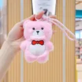 Close-up of cute pink plush bear keychain with red bow, soft toy detail for bags and keys. - Pink Bear