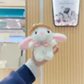 Close-up of a cute white plush rabbit toy pendant wearing a stylish hat and pink bow. - Regular Hanging Chain / White
