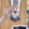 Close-up of the fluffy penguin plush keychain with soft fur, orange beak, and blue striped bib. - 12cm Standard Chain / Blue Scarf