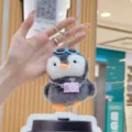 Adorable chubby penguin plush keychain toy featuring miniature camera and cool sunglasses close up - With Pink Camera
