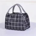 Dettaglio della borsa porta pranzo a quadri neri e bianchi con tessuto resistente e chiusura a zip. - 21*15*16 cm / Nero