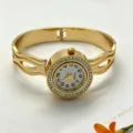 Detailopname van een gouden titaniumstalen horloge met strass-bezel en opengewerkte band - Dubbellaags Opengewerkte Gestroomlijnde Stijl (YF-26SZ00318)