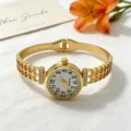 Nahaufnahme einer eleganten Damen-Goldarmbanduhr mit Hohlmuster und Strasssteinen - Retro-Stil mit stromlinienförmigen, diamantbesetzten Bandanstößen (JYD-24SZ00942)