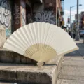 Elegant cream-colored blank folding fan with carved bamboo ribs for DIY or weddings. - Style P No.12 Hollow Carved Colored Paper Fan (Beige)