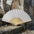 Blank white DIY folding fan with natural bamboo ribs on a graffiti stone step background - Style R No.1 Smooth Surface Colored Paper Fan (White)