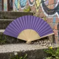 Handheld purple silk folding fan with natural bamboo ribs displayed on urban stone steps - Style R No.15 Plain Colored Paper Fan (Deep Purple)