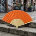 Traditional handheld folding fan with bright orange silk fabric and natural bamboo frame - Style Q No.4 Plain Colored Fabric Fan (Orange + Edged)
