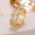 Detail shot of a golden wave honeycomb hollow-out ring, micro-inlaid zircon jewelry piece. - Size 6 / Gold