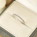 Nahaufnahme eines zarten silbernen Pave-Rings mit funkelnden rosa Steinen in Schachtel. - Größe 6 / Silber Violett