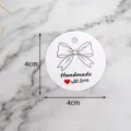 Primo piano di un'etichetta regalo rotonda e bianca con fiocco e scritta d'amore. - Etichetta con Fiocco LH-343 / Confezione da 100 / Bianco