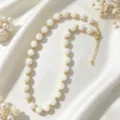 Elegant white beaded clavicle chain with gold spacer beads, minimalist chic design for women. - White