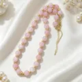 Delicate pink beaded necklace with gold accents, elegant clavicle chain detail close-up. - Pink
